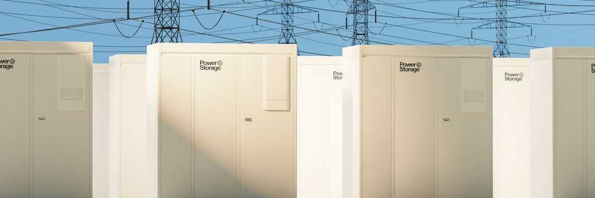 Grid-scale batteries aligned in rows with transmission lines behind