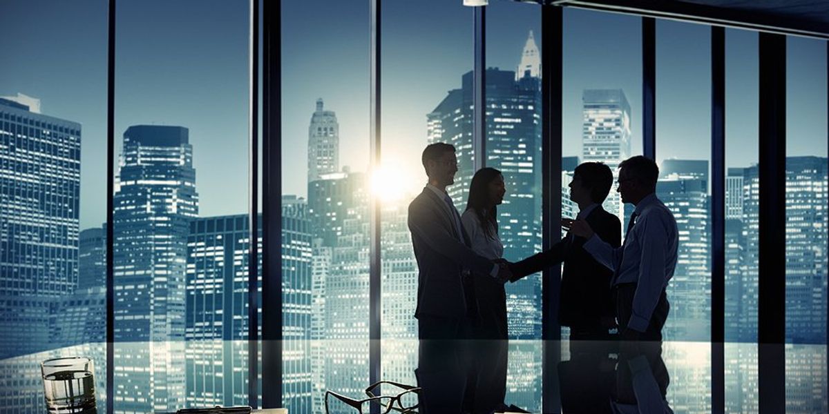 Group of people in a city conference room shaking hands.