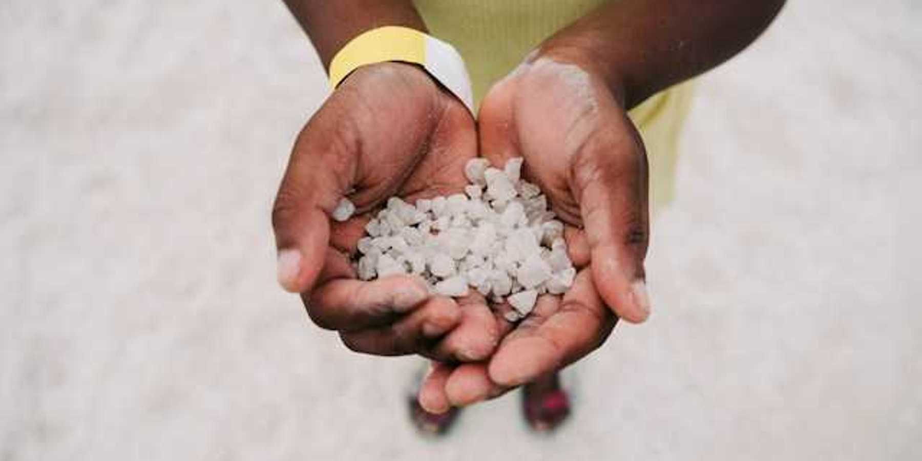 Hands cupped holding many hail particles