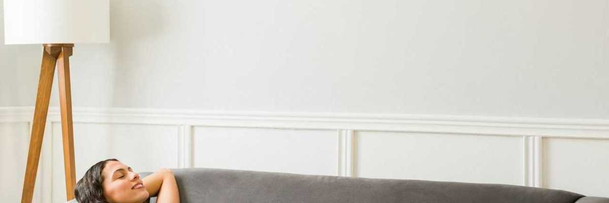 Happy woman relaxing in cool comfort underneath a mini-split heat pump