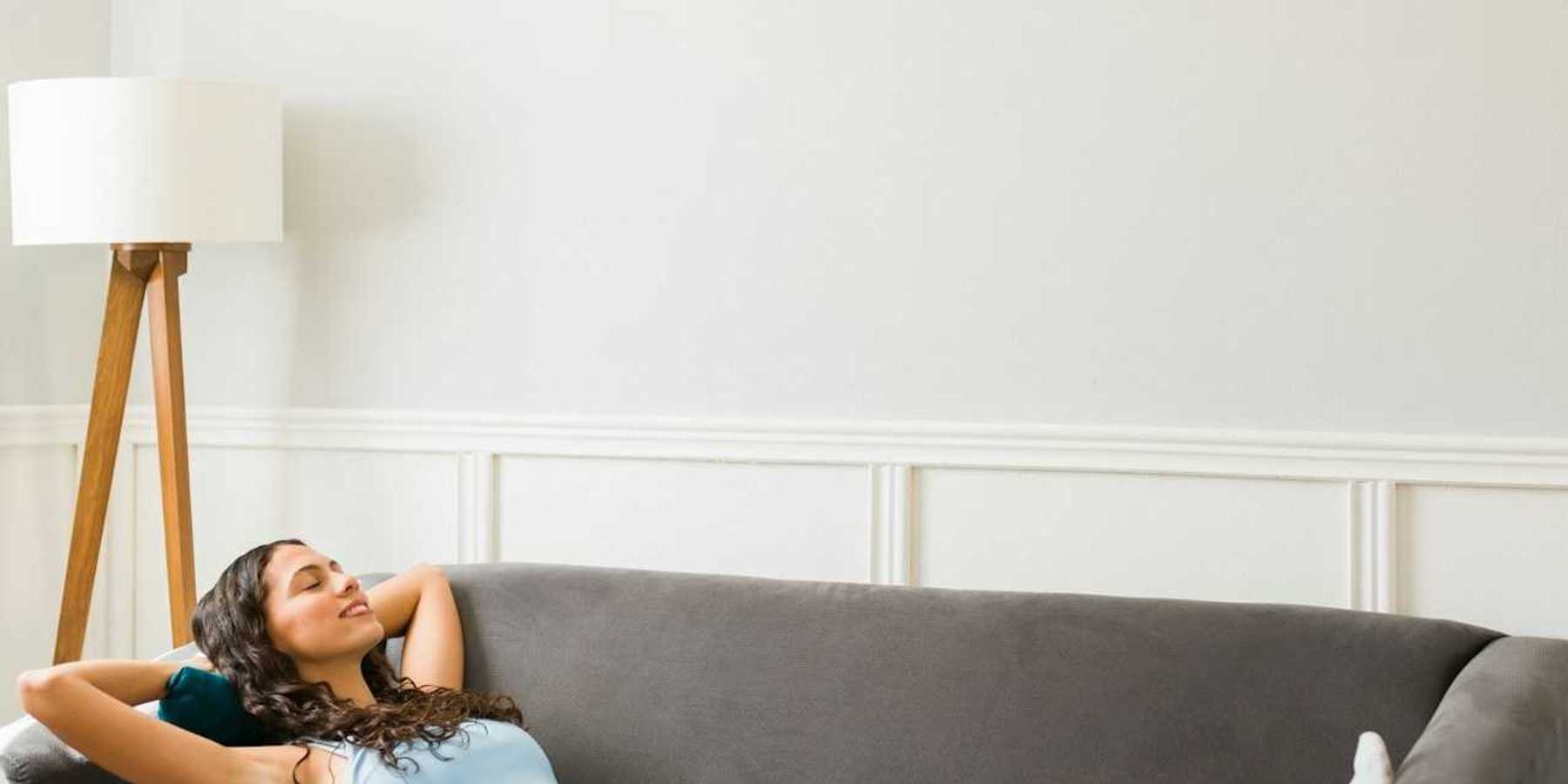 Happy woman relaxing in cool comfort underneath a mini-split heat pump