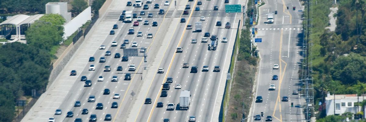 Heavy traffic on a multi-lane highway through hills.