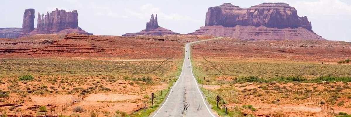 Highway in the American Southwest stretching towards distant mesas