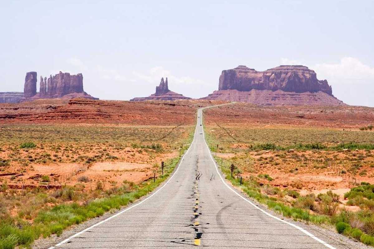 Highway in the American Southwest stretching towards distant mesas