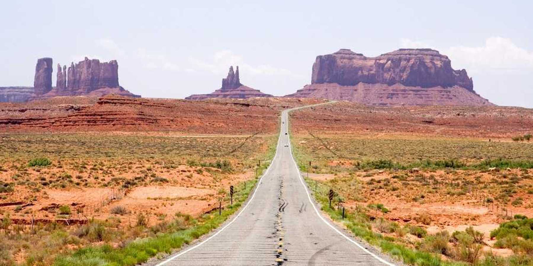 Highway in the American Southwest stretching towards distant mesas