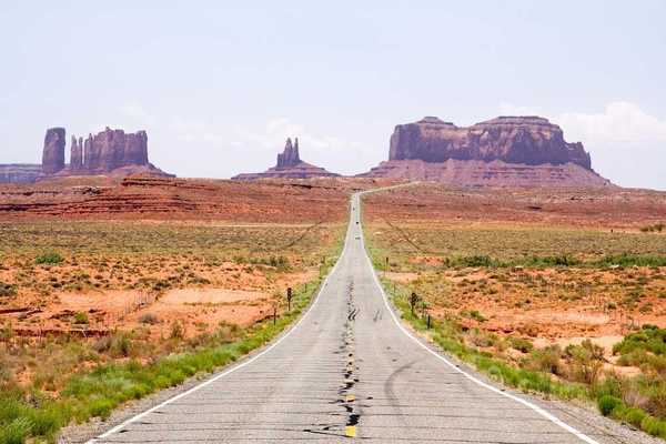 Highway in the American Southwest stretching towards distant mesas