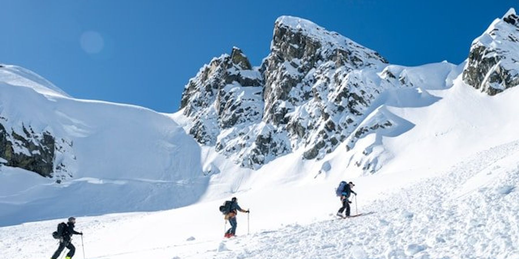 Hikers making their way up a snowy mountain.