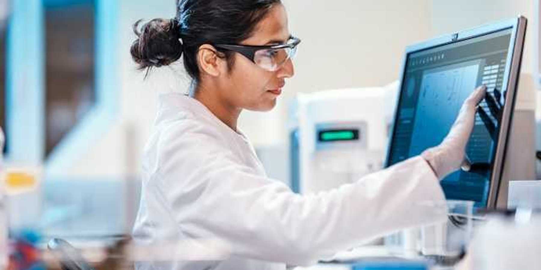 Hospital lab scientist manipulating data on a computer