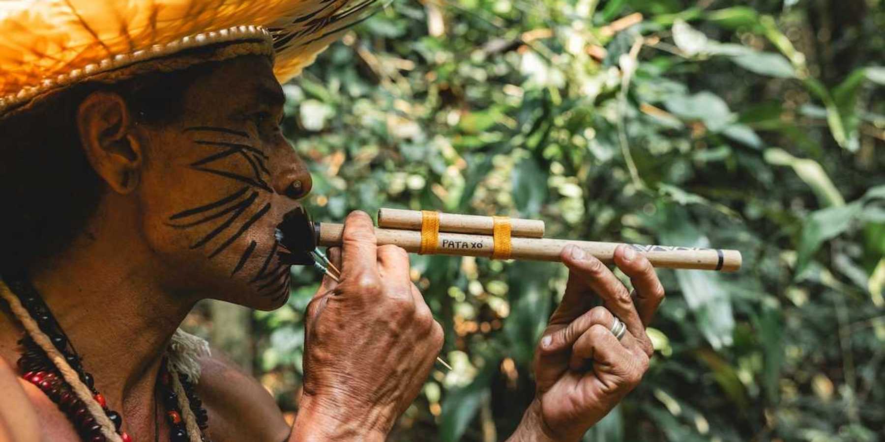 Indigenous Amazonian person using a blow-dart gun