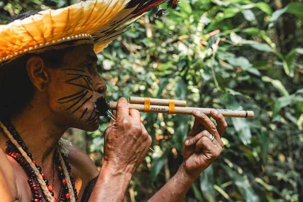 Indigenous Amazonian person using a blow-dart gun