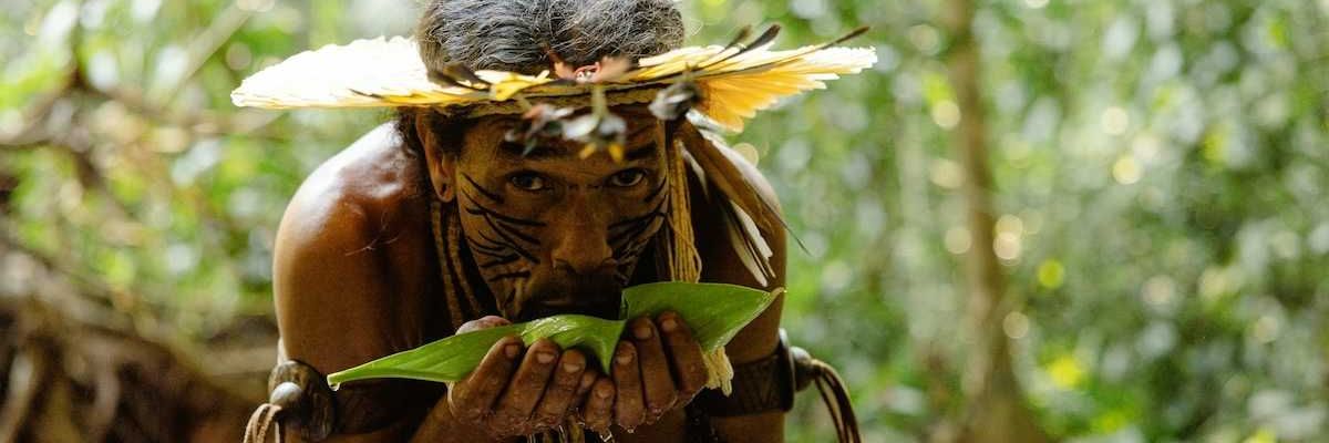 Indigenous Amazonian tribesman sipping water from a leaf