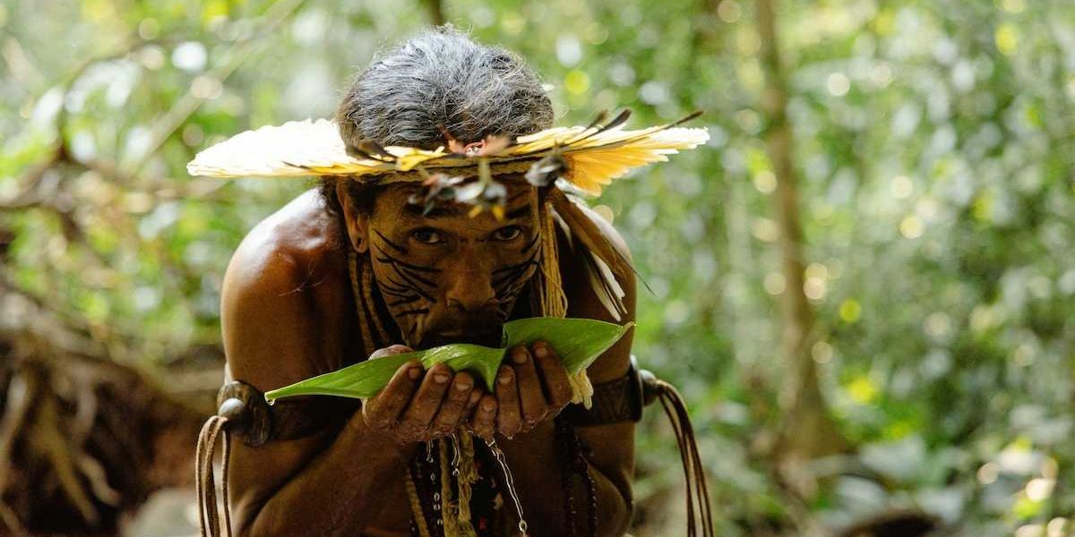 Indigenous Amazonian tribesman sipping water from a leaf