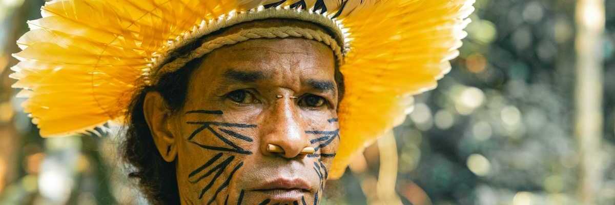 Indigenous Amazonian tribesman wearing yellow feathered headress