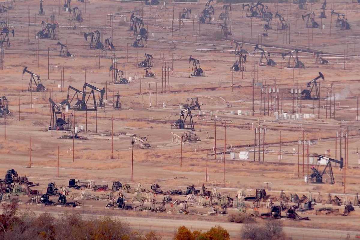 Industrial landscape, oil derricks in desert valley.