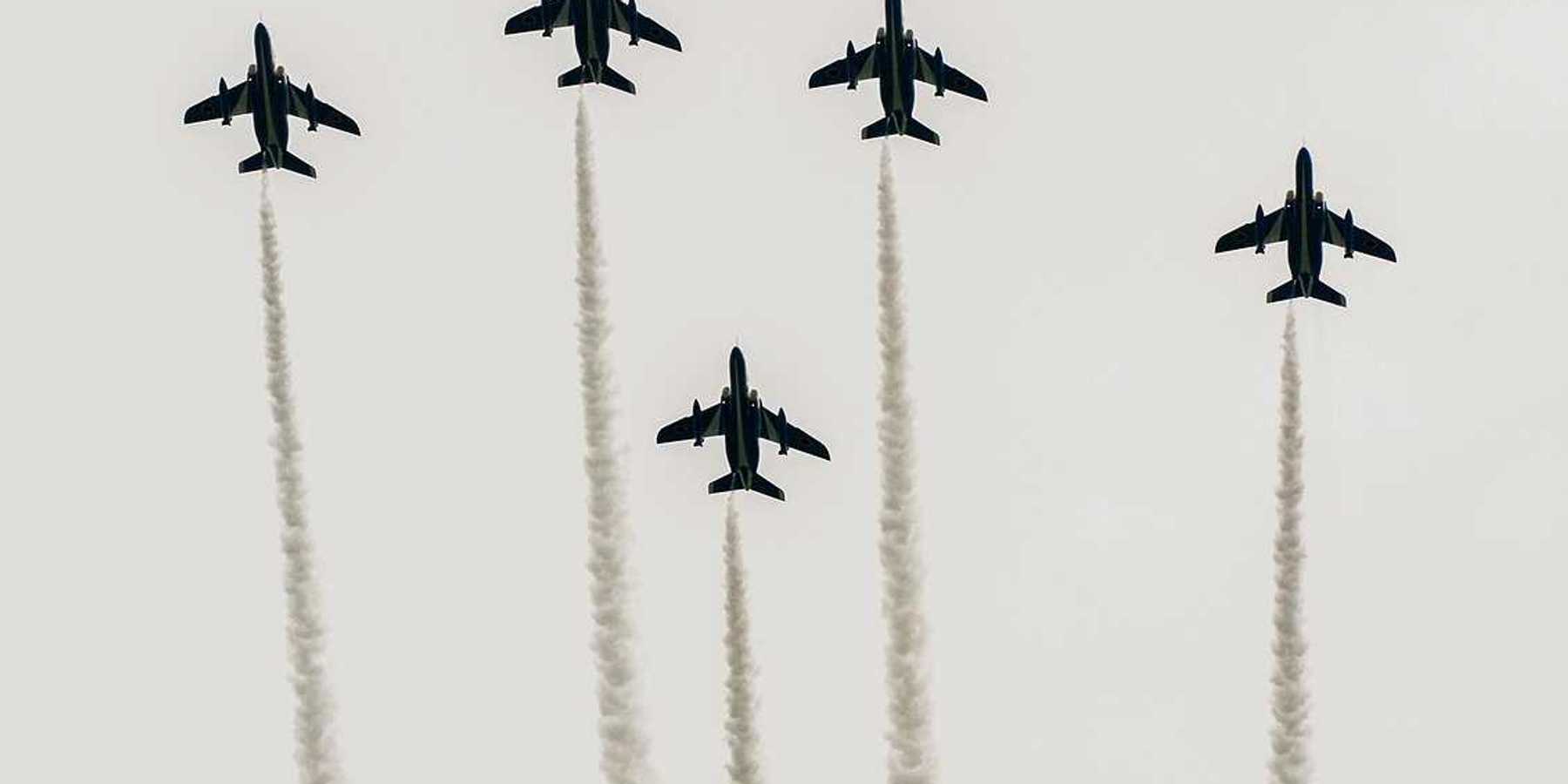 Japanese fighter jets perform maneuvers in flight formation for military drills.