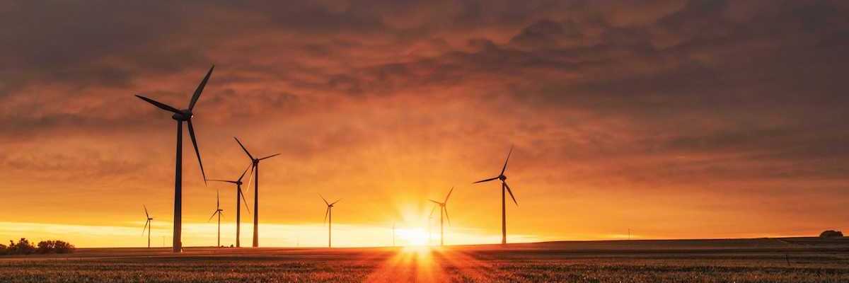 Land-based wind turbines against a rising sun