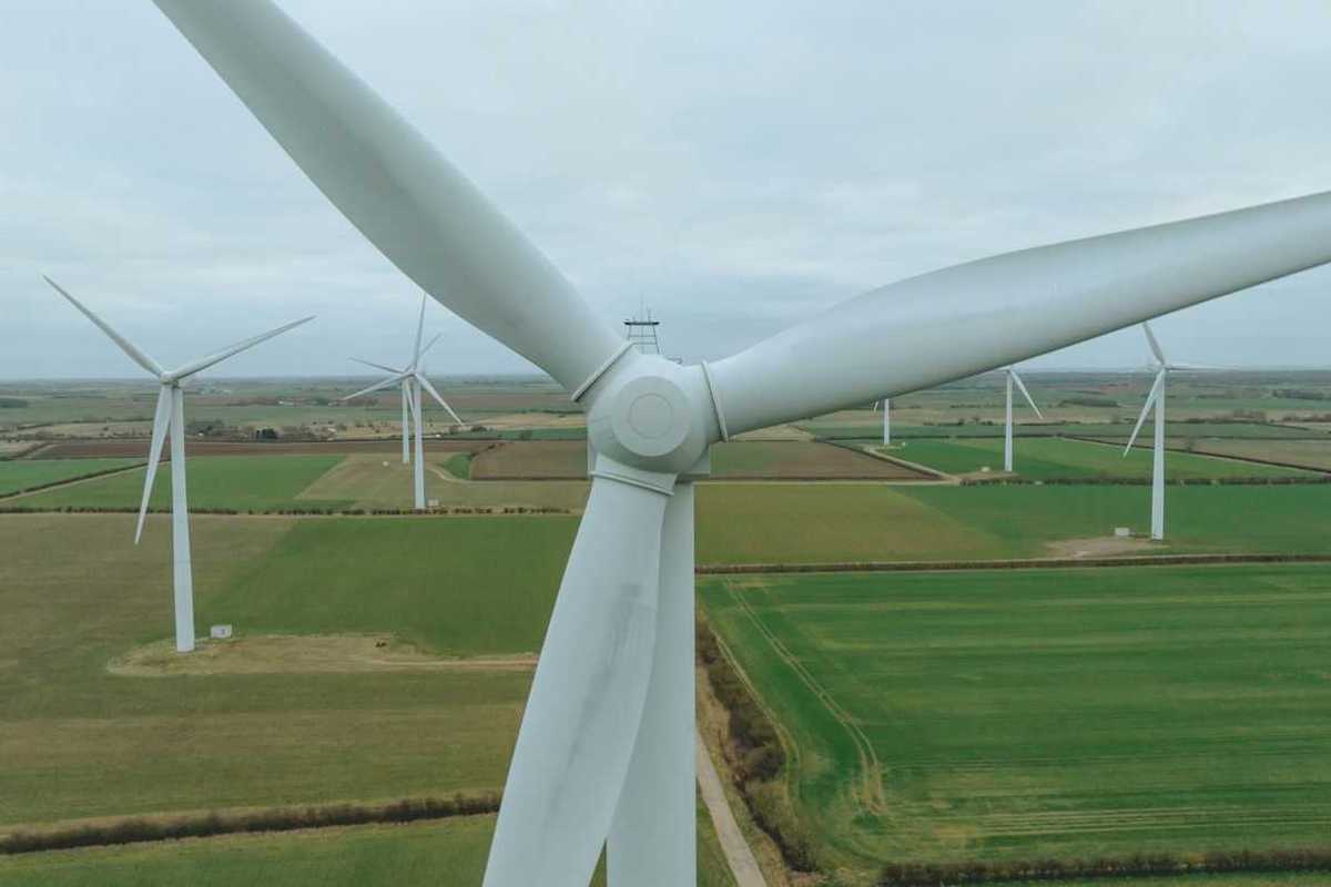 Land-based wind turbines on flat green landscape
