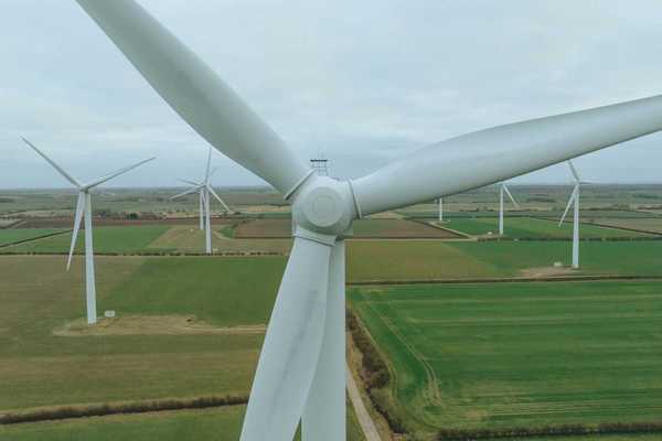 Land-based wind turbines on flat green landscape