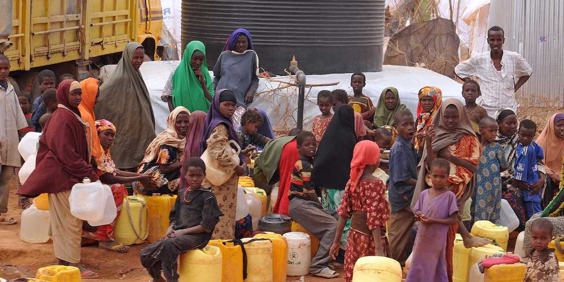 Large group of African people waiting to get water.