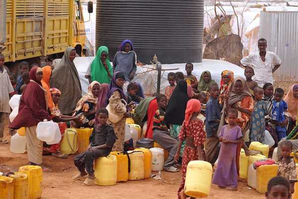 Large group of African people waiting to get water.