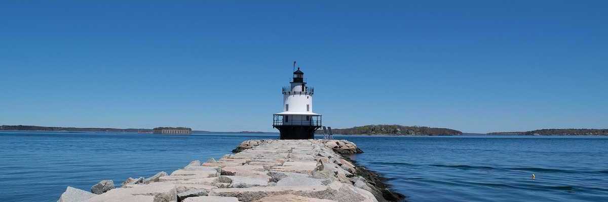 Lighthouse with a blue sky and sea wall