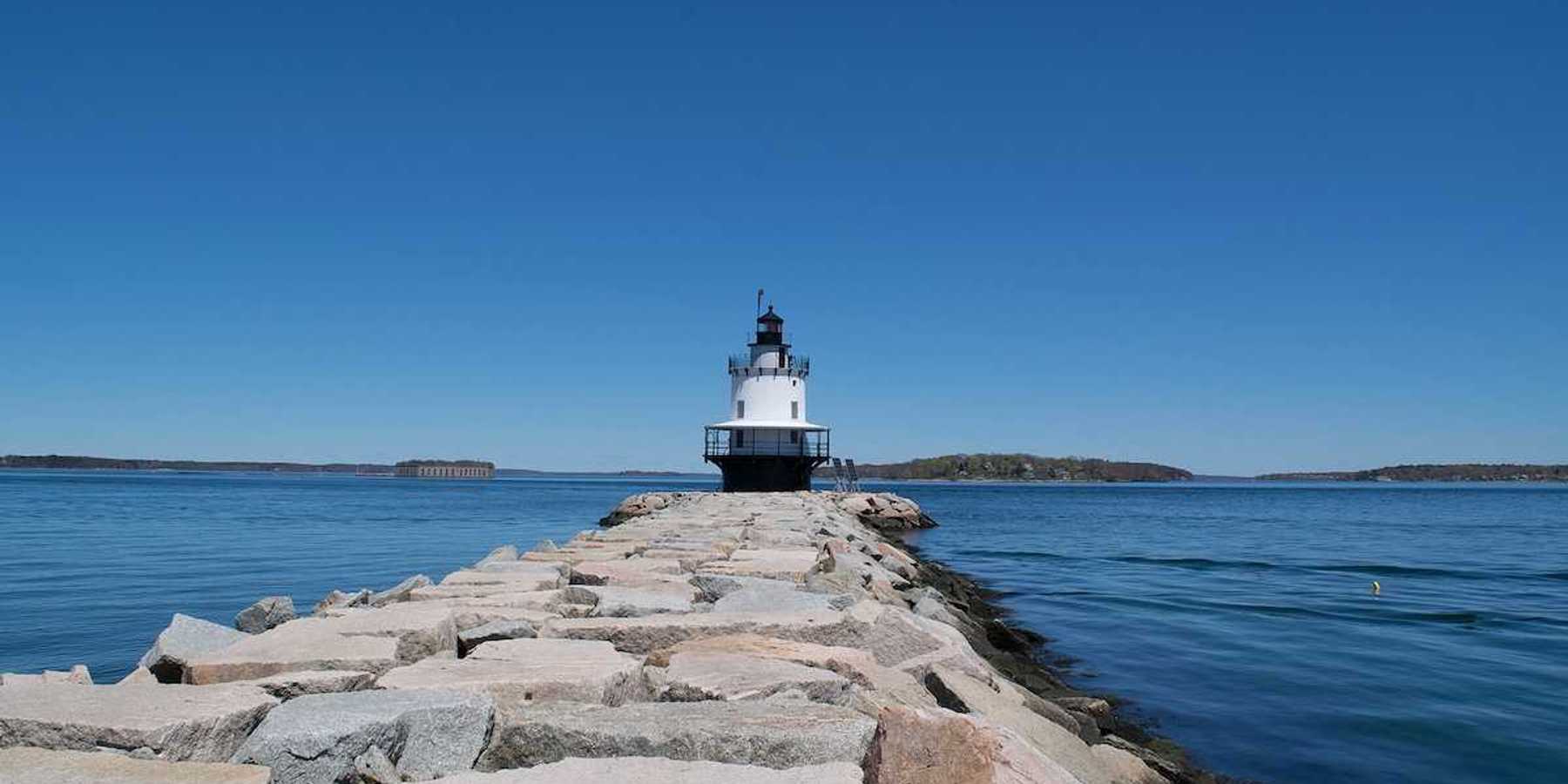 Lighthouse with a blue sky and sea wall