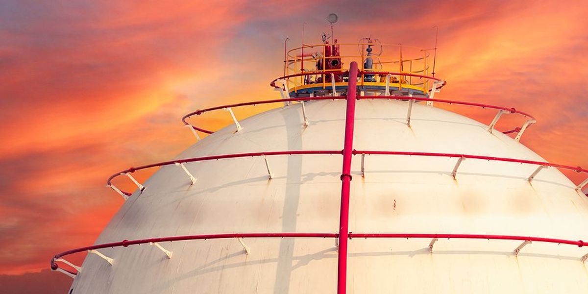 LNG storage tank with a red sky in the background.