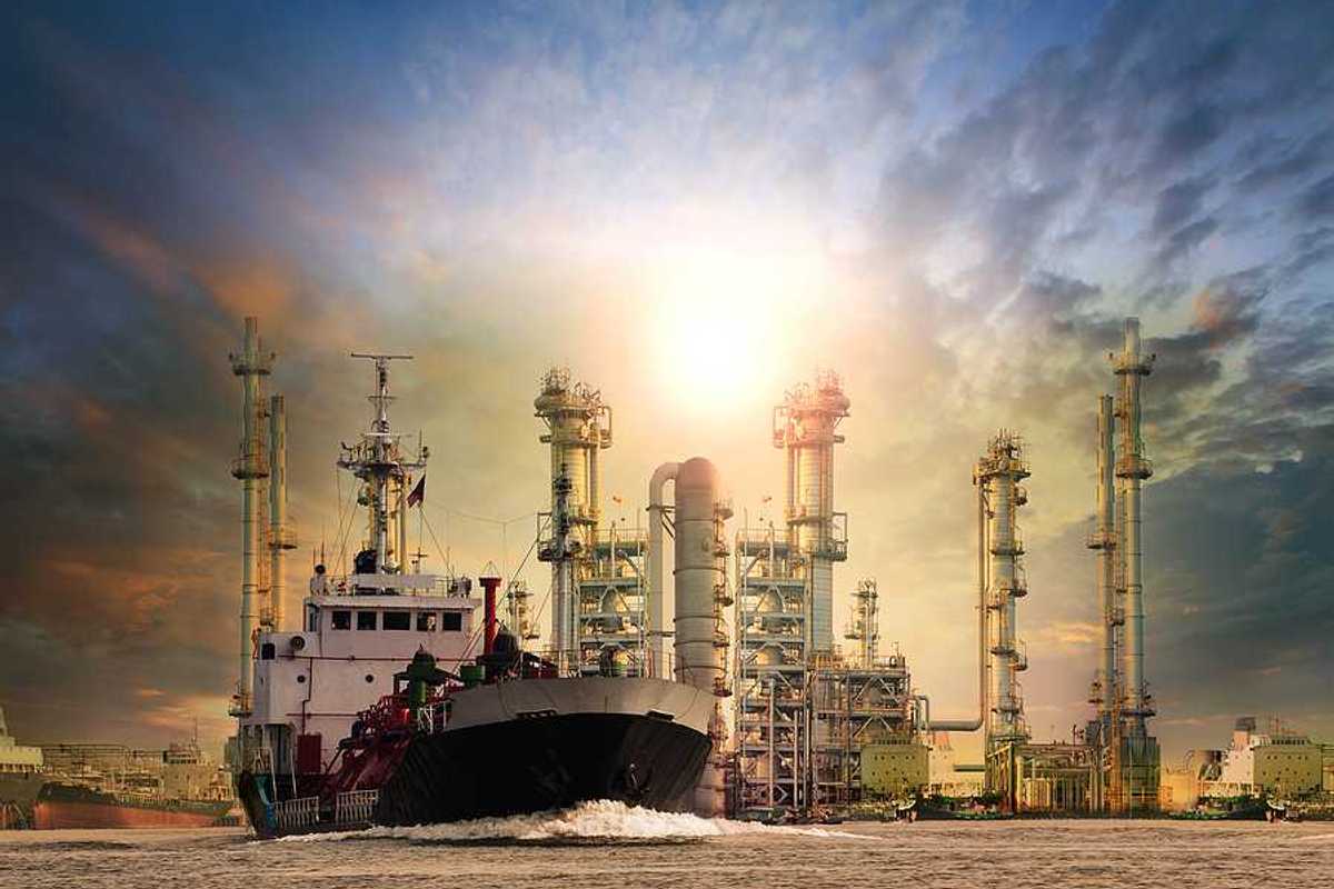 LNG tanker ship with oil and gas refinery plant in background