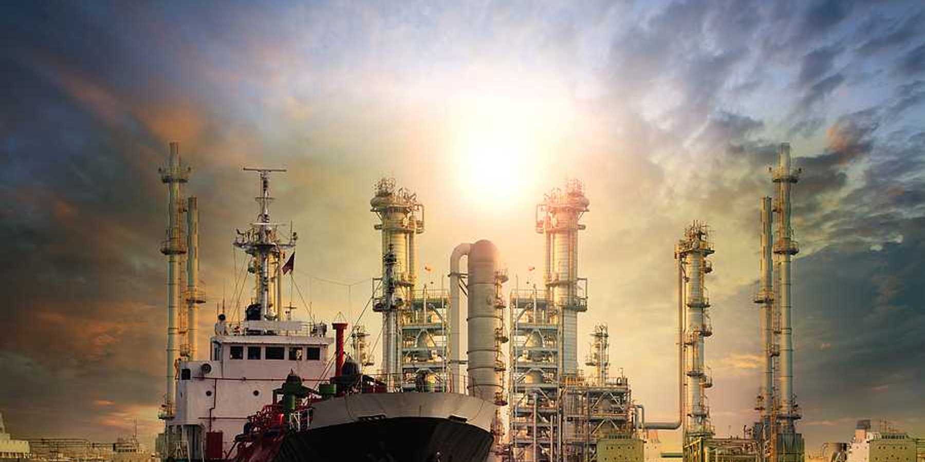 LNG tanker ship with oil and gas refinery plant in background