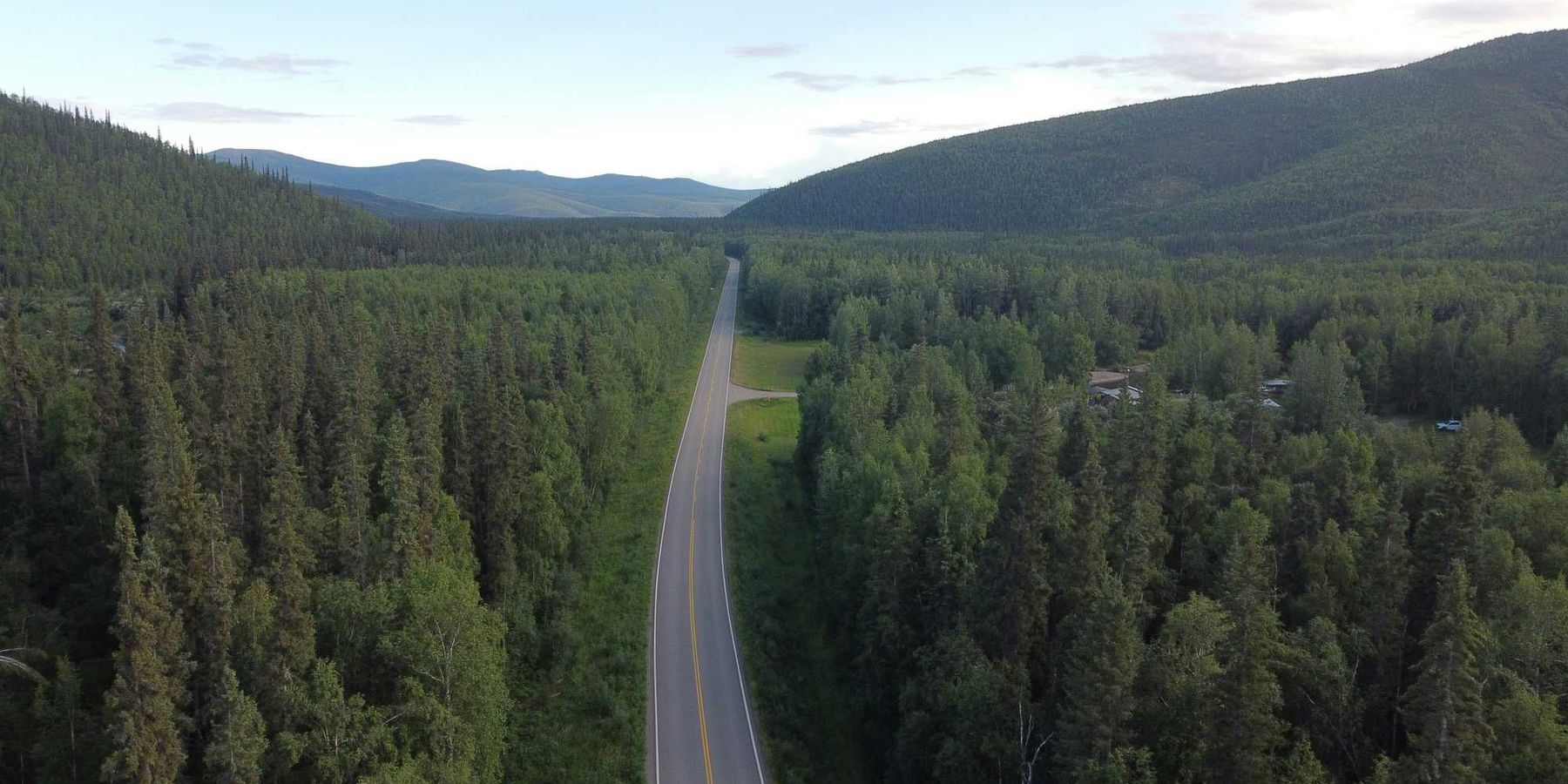Long highway through a dense forest landscape