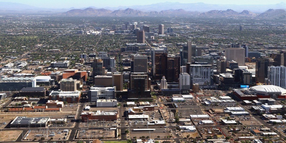 Looking down on a city in the desert with mountains in the background.