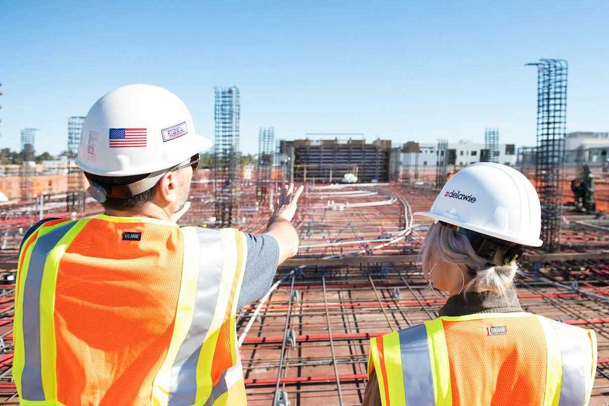 Man and woman in reflective vests reviewing a construction site