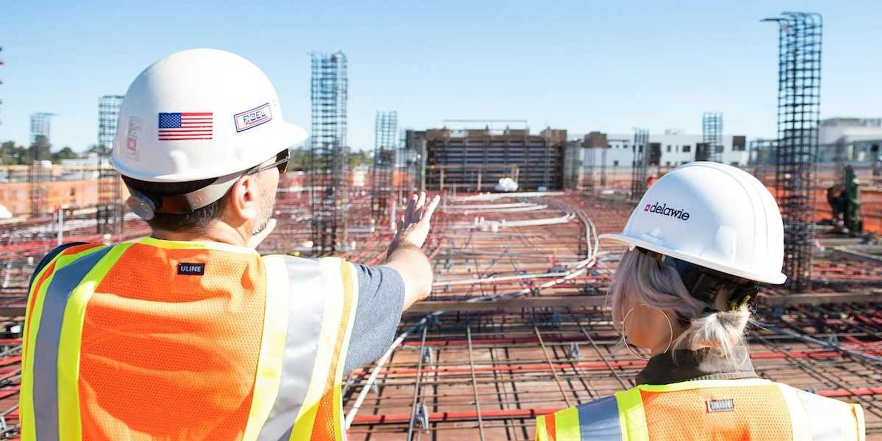 Man and woman in reflective vests reviewing a construction site