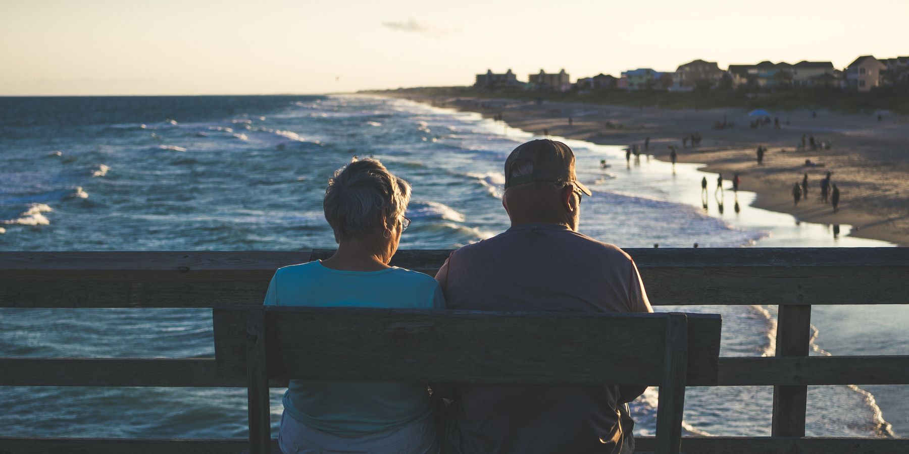 man and woman sitting on bench at beach