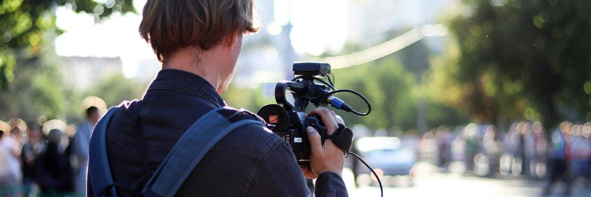 man in black jacket holding black dslr camera