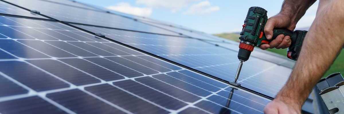Man installing solar panels on a roof
