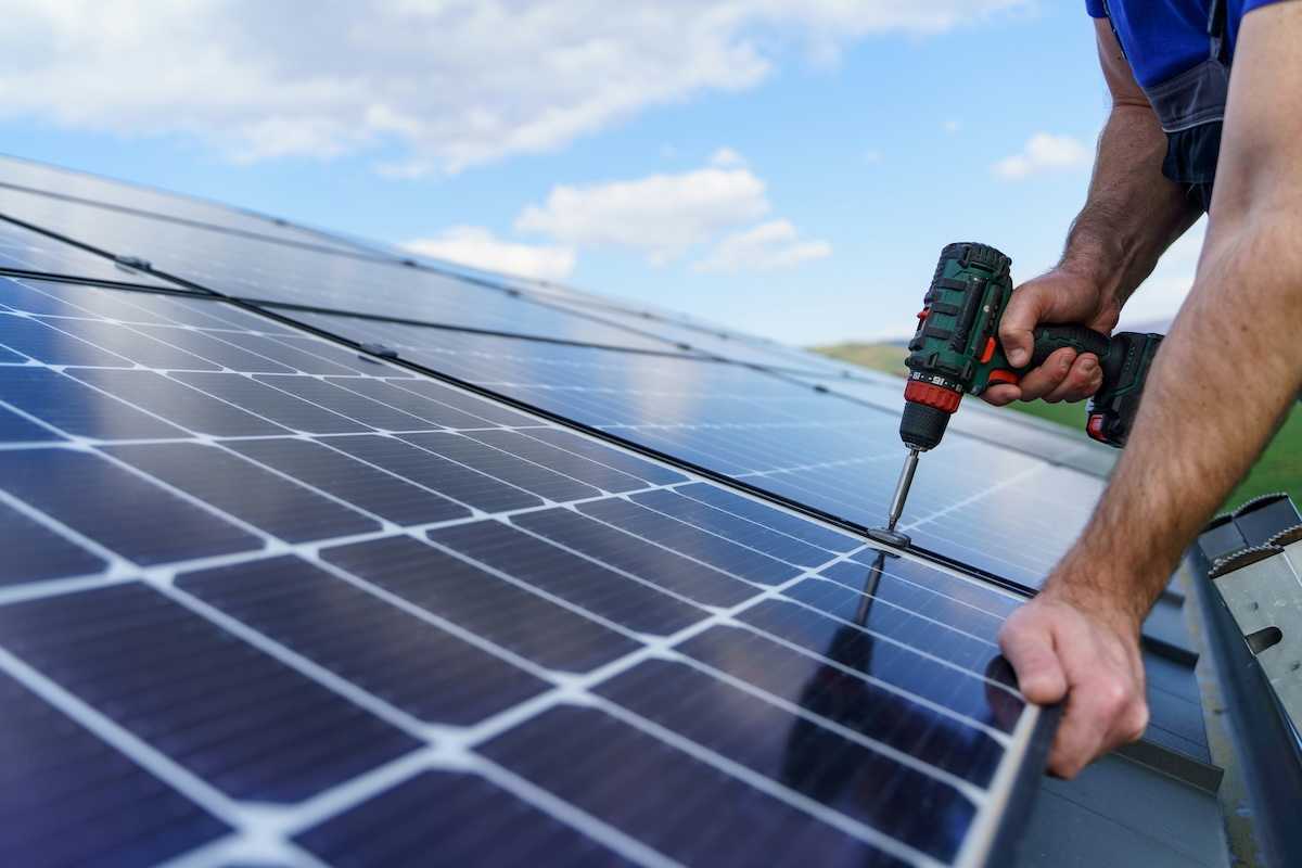 Man installing solar panels on a roof
