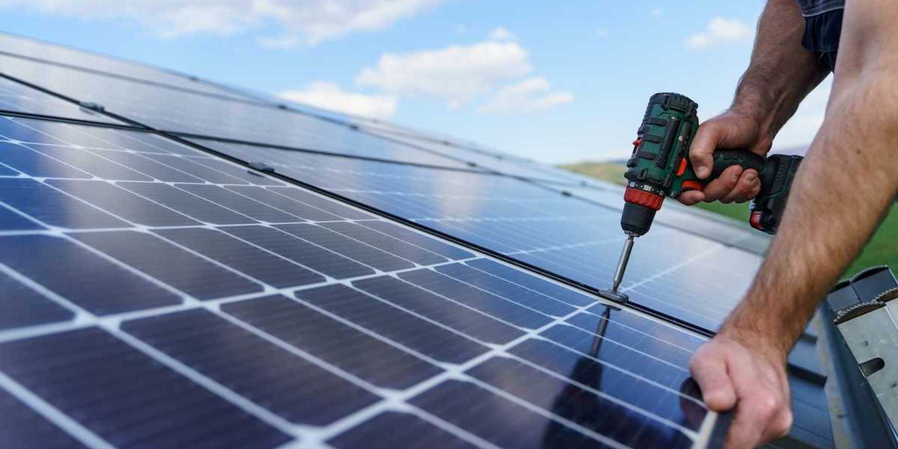 Man installing solar panels on a roof