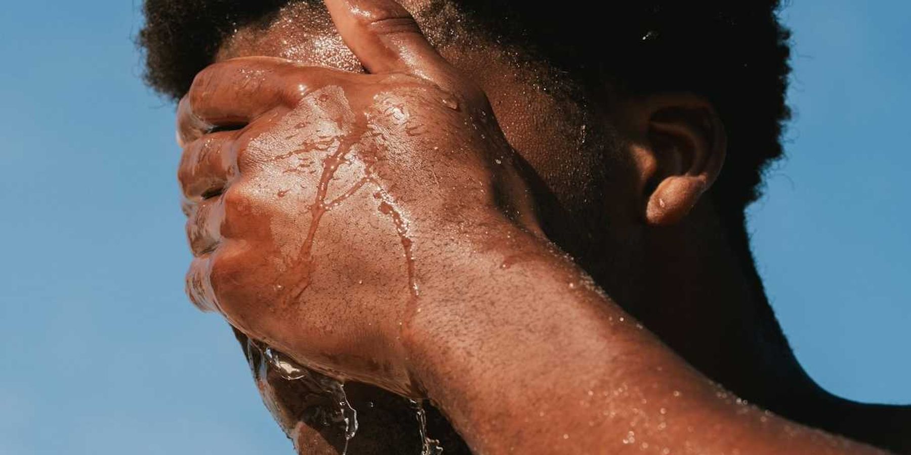 Man splashing water on face for heat relief