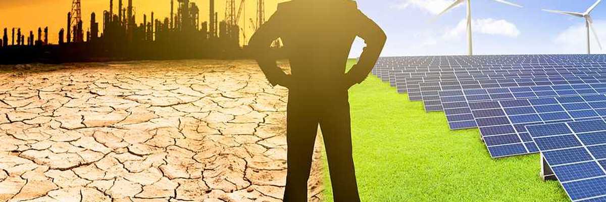 Man with hands on hips watching windmills solar panels and refinery spewing air pollution