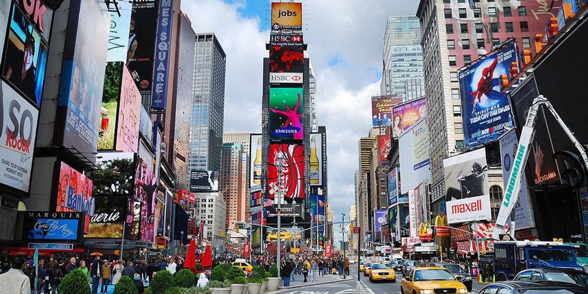 Manhattan's Times Square with tall buildings and cars on the street.
