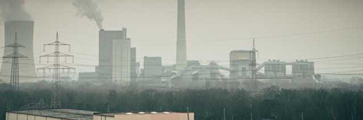 Manufacturing plant with smoke rising from towers