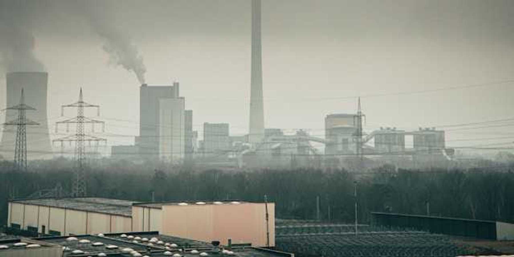 Manufacturing plant with smoke rising from towers