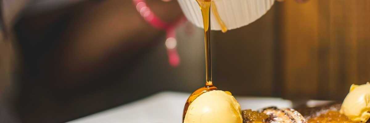 Maple syrup being poured over pancakes