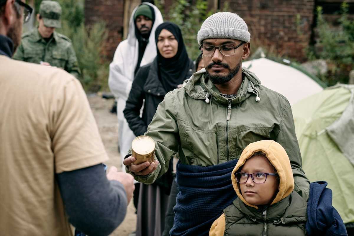 Men women and children lined up to receive food rations.