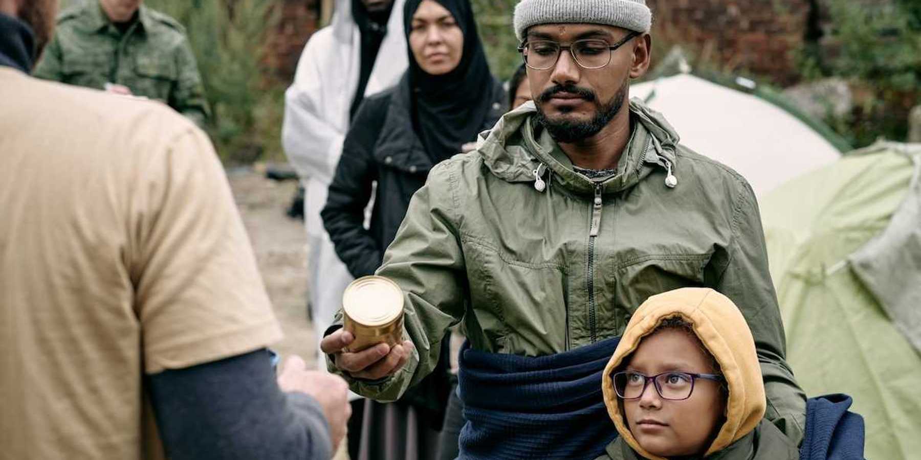 Men women and children lined up to receive food rations.
