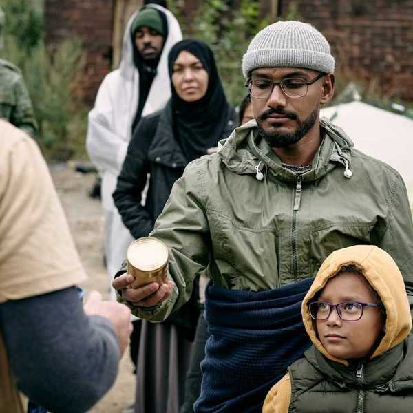 Men women and children lined up to receive food rations.