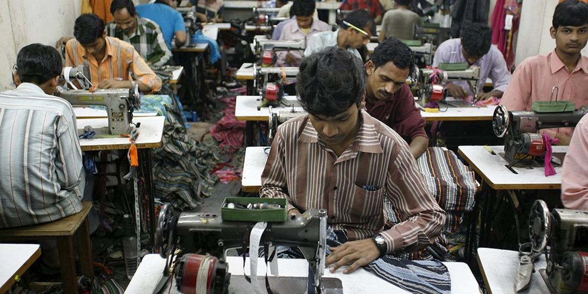 Men work with textiles and machinery in a factory