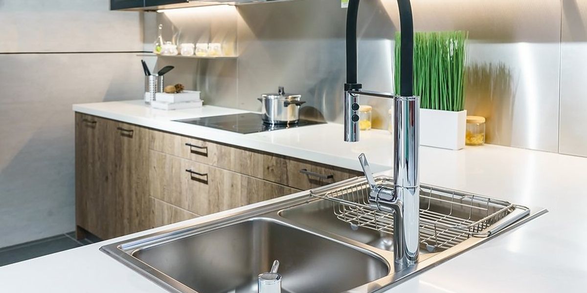 Modern kitchen with sink and electric stovetop.