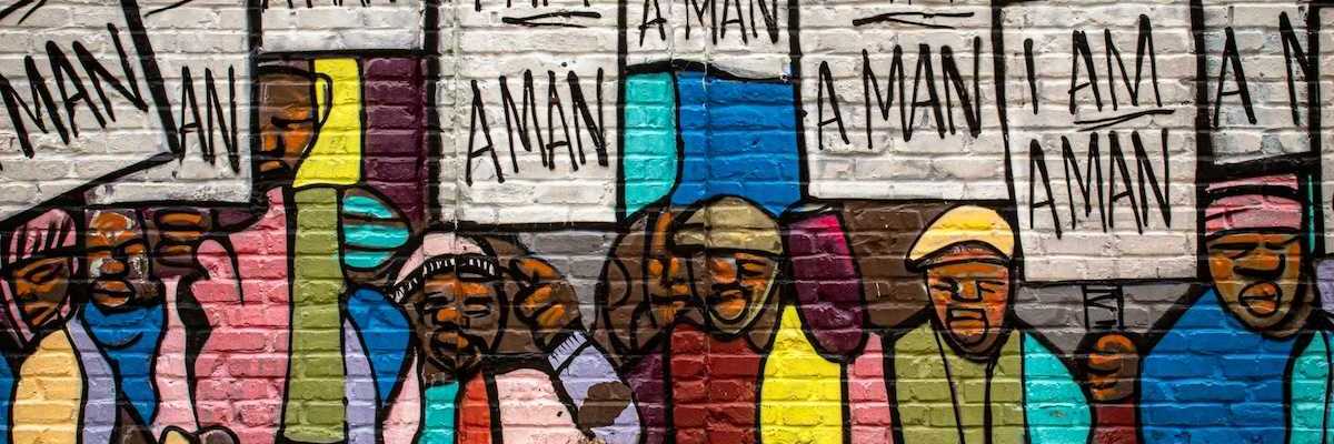 Mural on a building in Memphis painted during the Civil Rights movement, depicting black men holding signs that read "I am a man."